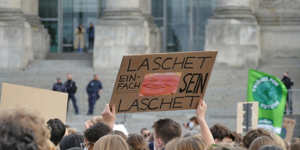 a group of people holding up signs in front of a building