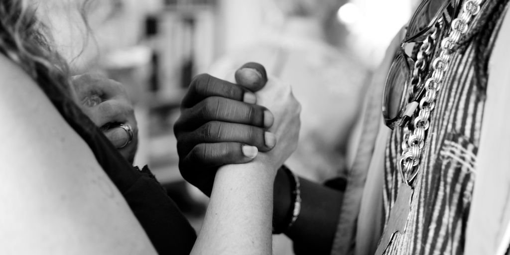 grayscale photo of man and woman holding their hands