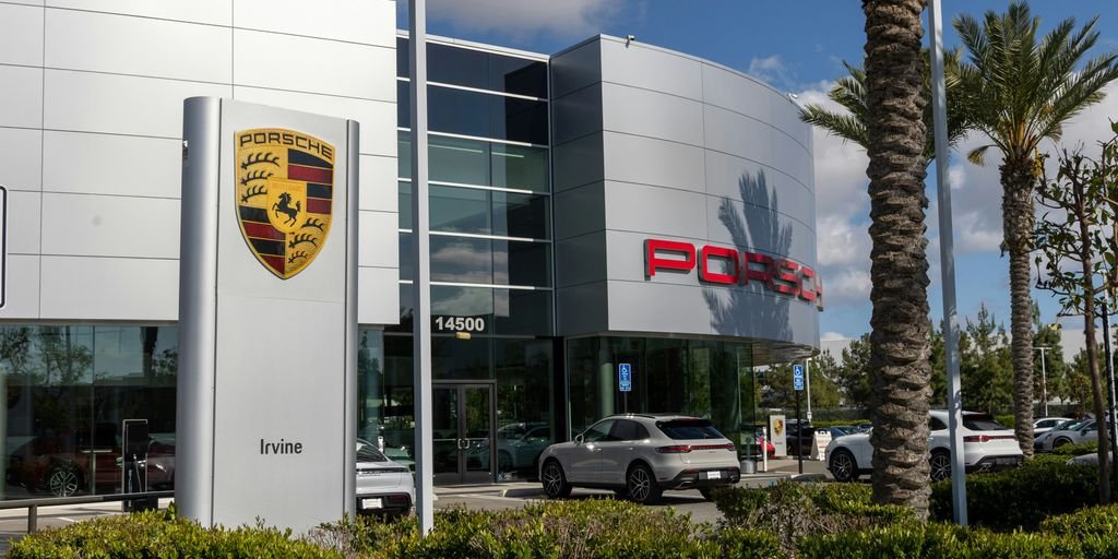 a porsche dealership with cars parked in front of it