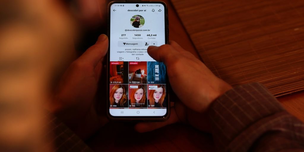 A person holding a cell phone with multiple pictures on the screen